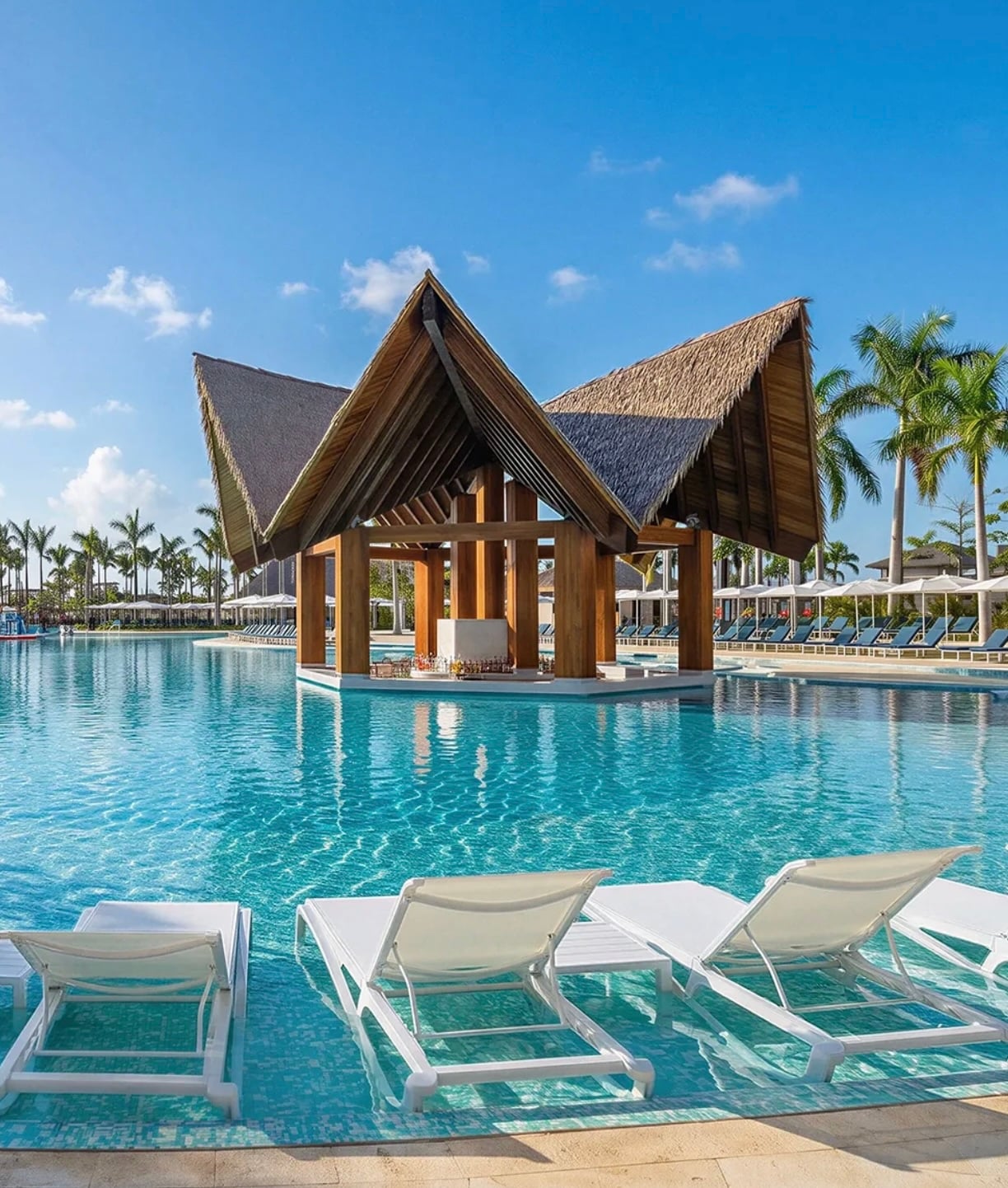 Luxury resort pool with swim-up loungers and a tropical pavilion